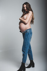 Stylish young pregnant girl, studio photography.