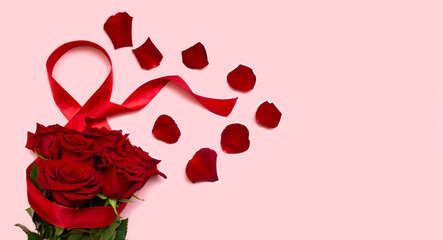 March 8, the concept of the international Women's Day holiday, Red roses on a pink background with a red ribbon and rose petals, a blank for a postcard, a place for the text