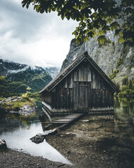 Boathouse at the Obersee in the bavarian alps with mountains in the background and clouds on the sky near Berchtesgaden