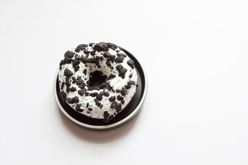 A donut covered with chocolate frosting and decorated with colored sprinkles isolated on a white background. Delicious colorful chocolate doughnut