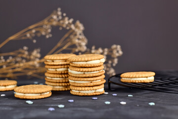 Cream filled sandwich double cookies on dark background