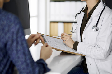 Doctor and patient discussing current health examination while sitting in clinic. Perfect medical service in hospital. Medicine concept