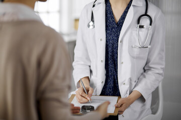 Doctor and patient discussing current health examination while sitting in clinic. Perfect medical...
