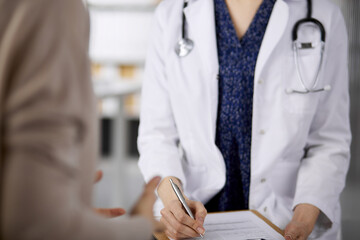 Doctor and patient discussing current health examination while sitting in clinic. Perfect medical...