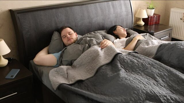 couple waking up looking into phone