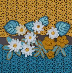 Fototapeta na wymiar Decorative flowers on a yellow and blue fabric background.
