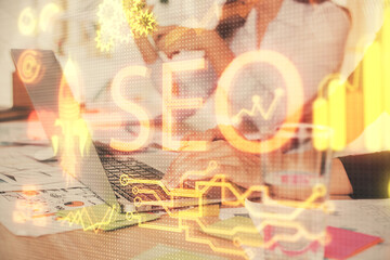 Double exposure of woman hands working on computer and seo hologram drawing. internet search concept.
