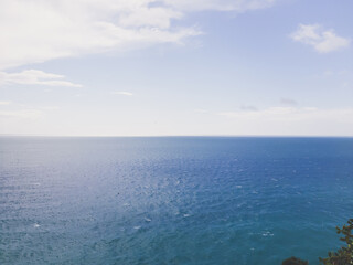 Fototapeta premium Genova, Italy - March 12, 2021 - Seascape, blue sky, clouds and sea in the tropical waters of the Mediterranean sea in winter days.