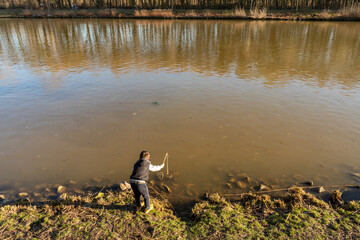 Ein Junge 7 spielt am Ufer am Wasserkanal