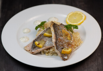Lemon-spiked sea bream fillet, cooked wheat risotto on plate