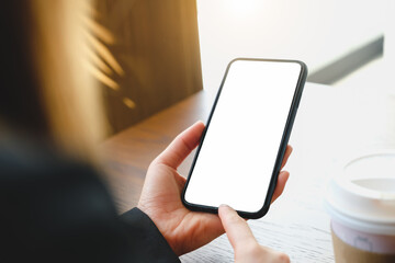 Close up of women's hands holding cell telephone with blank copy space scree for your advertising text message or promotional content, hipster girl watching video on mobile phone during coffee break.