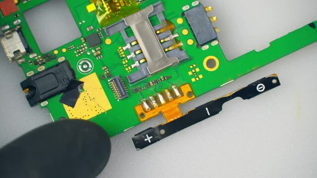 Close-up shot of electronics repair. Electronics repair soldering microchips and circuit boards at computers and electronics service. shooting via macro lense.