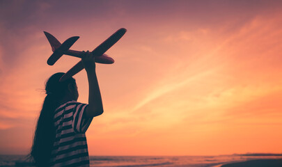 Silhouette asian girl playing aeroplane on the beach, Hopeful or future challenge concept © Danai
