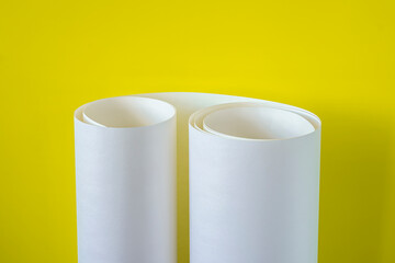 Roll of white paper on a yellow background.