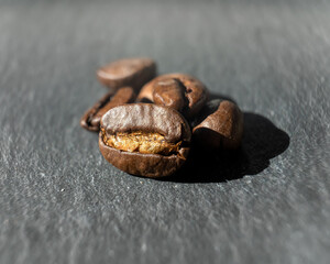 Kaffee Bohnen auf einem Schiefer Stein Untergrund in kräftigen Farben