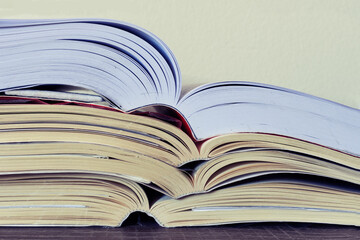 Closeup of a pile of open books on a table. School, College, University concept. Copy space.