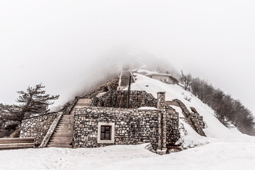 Stone house on the mountain hidden in the fog in Lovcen national park