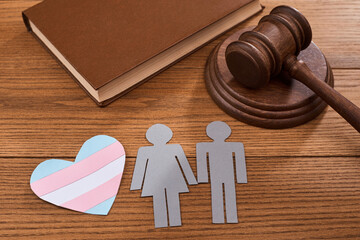 A paper heart with transgender pride flag, a couple, a judge s gavel and a book