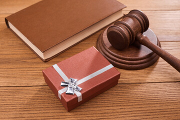 A gift box, a judge s gavel and a book on wooden table