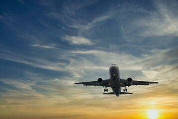 Das Flugzeug gegen den blauen Sonnenunterganghimmel. Die untergehende Sonne
