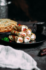 Thin pancakes with herbs, salmon and cream cheese on a plate. crepes