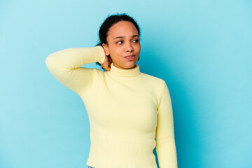 Young african american mixed race woman isolated touching back of head, thinking and making a choice.