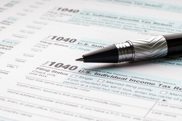 Tax Form 1040 and ballpoint pen. Filling in a tax return.