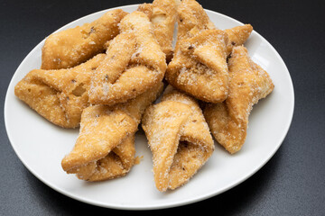 Pestiños on a white plate and black background