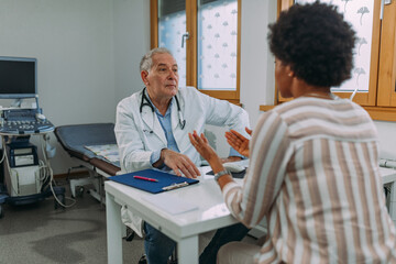 Senior doctor and his patient during examining at hospital