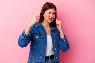 Young caucasian woman isolated on pink background upset screaming with tense hands.