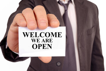 Homme montrant une carte sur laquelle est écrit nous sommes ouverts
