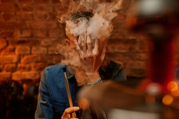 Young man relax in hookah bar, hooka smoke