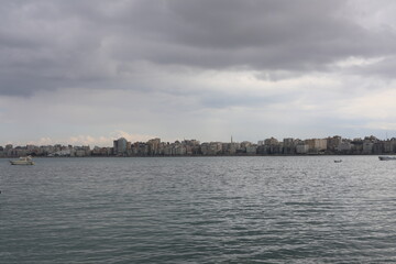 Obraz premium Boats in the harbor. View from coast in Mediterranean Sea. Scenic landscape on a rainy day. Heavy rain clouds. Beautiful Egyptian horizon with a lot of little fishing boats 