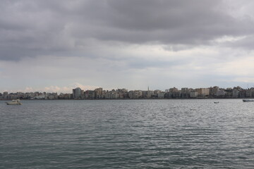 Naklejka premium Boats in the harbor. View from coast in Mediterranean Sea. Scenic landscape on a rainy day. Heavy rain clouds. Beautiful Egyptian horizon with a lot of little fishing boats 