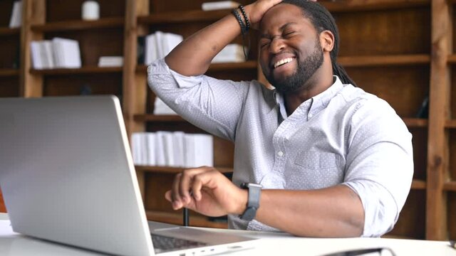 Concerned African-American young man is late, check time on a wristwatch, a sadness guy forgot about an important meeting, worried male does not have time to finish the project before the deadline