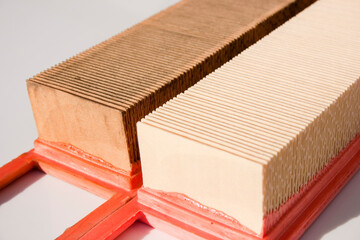 Old and new engine air filter. Replacing the air filter of the car engine. New and old air filter close-up on white surface