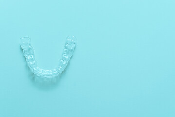 Invisible dental teeth brackets tooth aligners on turquoise background. Plastic braces dentistry...