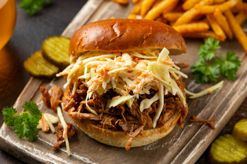 Homemade BBQ Pulled Pork burger with coleslaw, fries and beer
