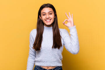 Young Indian woman isolated on yellow background cheerful and confident showing ok gesture.