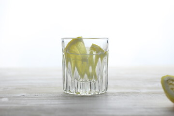 Vodka with fresh lemon in short glass on white background