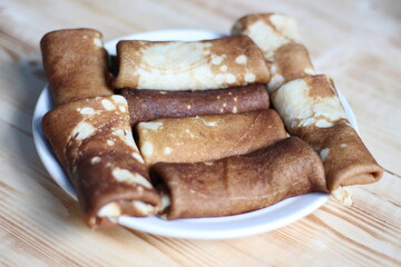 Stuffed panckakes on plate on wooden background for Maslenitsa