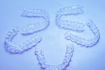 Invisible aligner teeth retainers on a blue background
