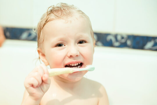 Toddler brushes teeth with a toothbrush. girl is taking a bath. Hygiene procedures before going to bed.