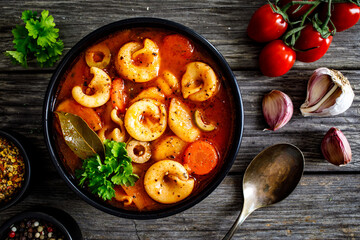 Tomato soup with noodles on wooden table
