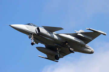 Fototapeta na wymiar Modern fighter jet flying with landing gear down