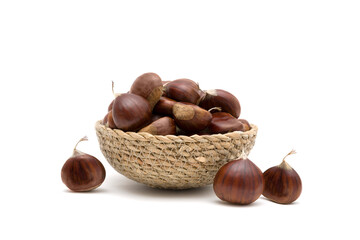 Obraz premium Fresh raw sweet chestnuts(Castanea sativa) in a wicker basket isolated on a white background