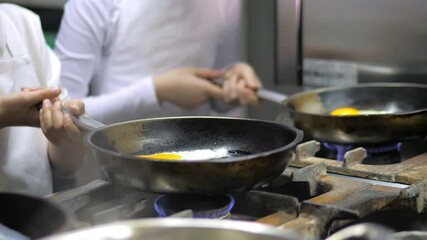 Kids learning how to cook eggs in a cooking class in restaurant kitchen