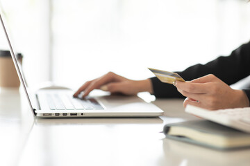 Online payment,Young Woman hands holding smartphone and using credit card laptop for online shopping.