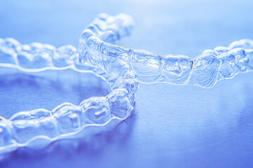 Invisible aligner teeth retainers on a blue background