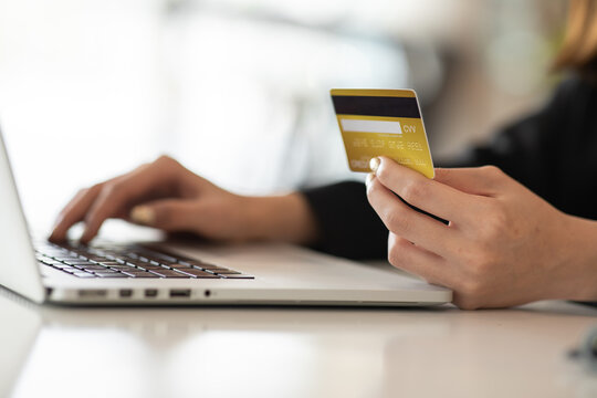 Online payment,Young Woman hands holding smartphone and using credit card laptop for online shopping.